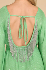 Close up back view of this dress that features an open back with a self-tie and beaded fringe detailing at the back.