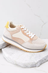 Outer-side view of these sneakers that feature white tie laces, a color block pattern, and a tan rubber sole.