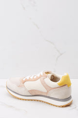 Inner-side view of these sneakers that feature white tie laces, a color block pattern, and a tan rubber sole.