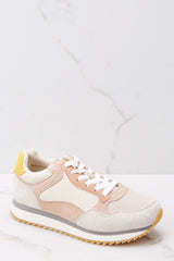These taupe color block sneakers feature white tie laces, and a tan rubber sole. 