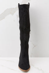 Front view of black knee high boots featuring a suede-like fabric. 