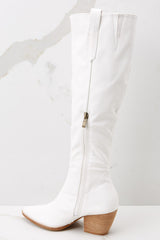 Inside view of white knee high boots with an inside zipper closure. 