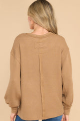 Back view of this top that features a round neckline, subtle bubble sleeves, a bottom hem that is approximately 2