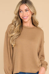 Front view of this top that features a round neckline, subtle bubble sleeves, a bottom hem that is approximately 2