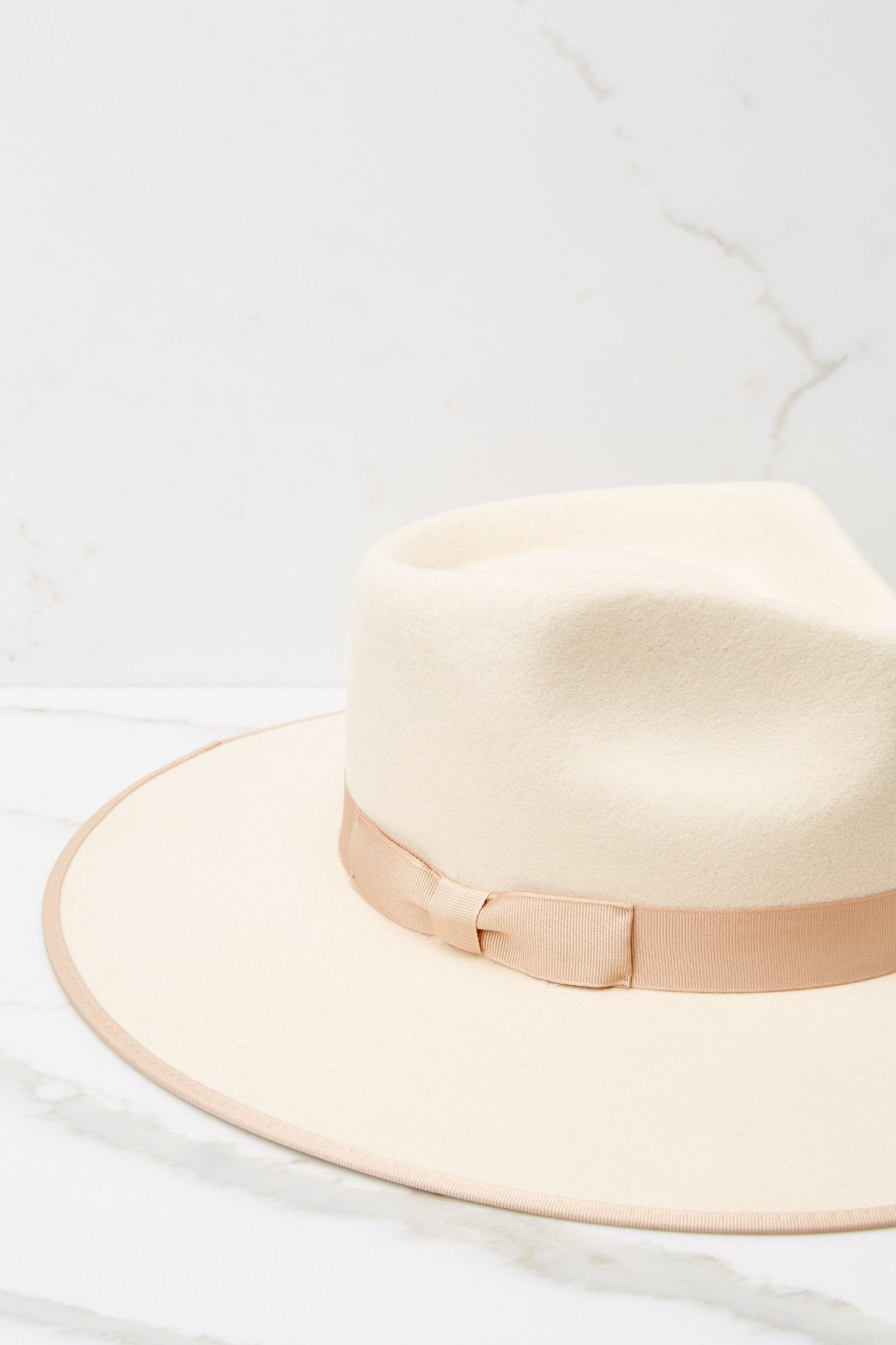 Close up view of this fedora that features a stiffened wool fedora complete with rigid crown design, and a trimmed on hat and rim with tonal gross grain ribbon.