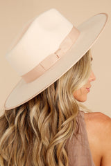 This ivory rancher fedora features a stiffened wool fedora complete with rigid crown design, and a trimmed on hat and rim with tonal gross grain ribbon.