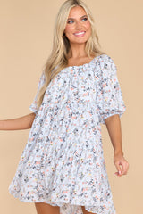 This blue dress features a square neckline, elastic detail along the neckline, puff sleeves, and a flowy relaxed body.