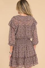 Back view of this dress that features a v-neckline with a self-tie closure, long sleeves with elastic cuffs, a smocked waistband, and a flowy skirt.