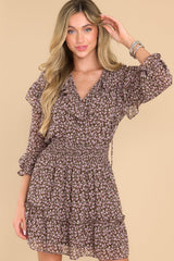 Front view of this dress that features a v-neckline with a self-tie closure, long sleeves with elastic cuffs, a smocked waistband, and a flowy skirt.