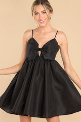 Front view of this dress that features a sweetheart neckline with a key hole detail on the bust, the bow at the bust is non-adjustable, adjustable spaghetti straps, zipper on the back, and a babydoll silhouette.