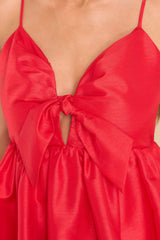 Close  up view of this dress that features a sweetheart neckline with a key hole detail on the bust, the bow at the bust is non-adjustable, and adjustable spaghetti straps.