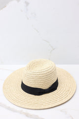 Angled top view of this hat that features a straw design and a black ribbon around the base of the hat.