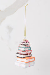 Back view of this ornament that features a design of stacked books with glitter accents and striped string.