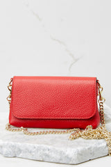 This red crossbody bag is made with real leather, has two detachable straps; one is a short matching leather strap, and the other is a curb chain crossbody strap.