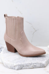 Outer-side view of  these ankle boots that feature a pointed toe, a side zipper closure, a stretchy side panel, and a stacked heel.