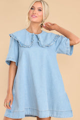 Front view of this dress that features a high neckline with a ruffled collar, and short sleeves functional zipper in the back.