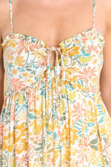 Close up view of this dress that features a sweetheart neckline, adjustable straps, a self-tie at the bust, a smocked insert at the back of the bust, side pockets, and a flowy skirt.