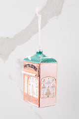 Angled side view of this ornament that features a building that says 