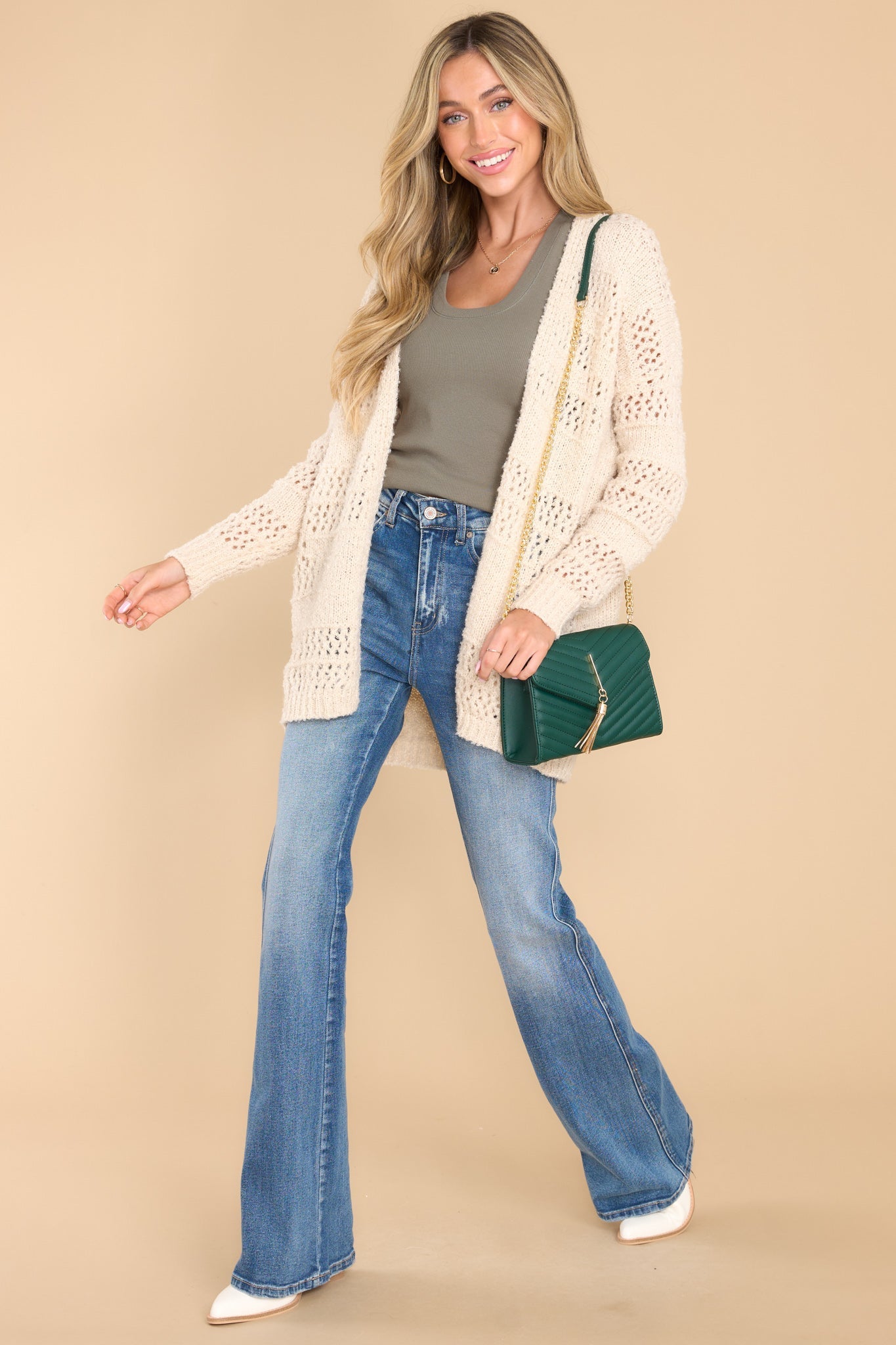 This all ivory cardigan features a textured design, ribbed detailing, and a soft fabric.