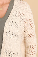 Close up view of this cardigan that features a textured design, ribbed detailing, and a soft fabric.