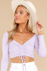 Front view of this crop top that features a scrunched center complimented by an adjustable self tie, a lower scoop neck, and a ribbed fabric.