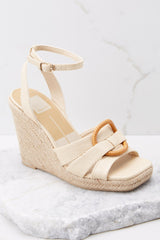 These beige wedges feature an adjustable strap around the ankle, detailed straps over the toes, and an espadrille style wedge.