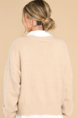 Back view of this sweater that features a v-cut neckline, long sleeves, and a ribbed waistband.