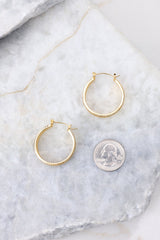 Encrusted gold hoop earrings compared to quarter for actual size. Earrings measure 1.25