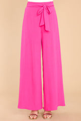 Front view of these pants that feature an elastic waistband in the back, a self tying belt, and a wide leg.
