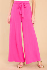 These fuchsia pants feature an elastic waistband in the back, a self tying belt, and a wide leg.