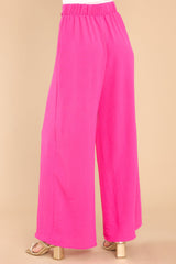 Back view of these pants that feature an elastic waistband in the back, a self tying belt, and a wide leg.