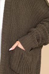 Close up view of this cardigan that features a soft, chunky knit design, and functional pockets.