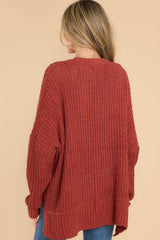 Back view of this cardigan that features a soft, chunky knit design, functional pockets, and small slits up the sides.