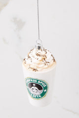 Top view of this ornament that features a pumpkin spice latte design with glitter details. 