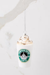 This white ornament features a pumpkin spice latte design with glitter details. 