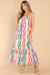 Full body view of this dress that features a square neckline, adjustable tie shoulder straps, elastic band around the chest, a cut out on the back, and a flowy silhouette. 