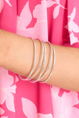On model view of sleek silver bracelet cuff featuring a slip on design.