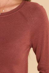 Close up view of this top that features a round neckline, ribbed detailing along the hem and cuffs, 3