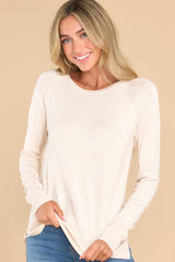 This oatmeal colored top features a round neckline, ribbed detailing along the hem and cuffs, 3
