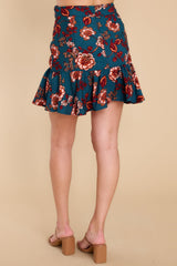 Back view of this mini skirt that features a high-waisted fit, a belt detail around the waist, and a flowy hem.