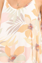 Close up view of this dress that features a v-neckline, thin straps, waist pockets, and a flowy fit. 
