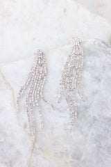 Close up view of these earrings that feature silver hardware, rhinestone-embellished dangles, and a secure post backing.