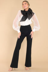 Full body view of  this top that features sheer puff sleeves with buttons at the cuffs.