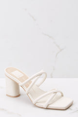 These ivory shoes feature a square toe, straps that cross over the foot, a slip on design, and a chucky heel.