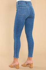 Back view of these skinny jeans that feature a high waisted fit, functional back pockets, and a relaxed fit around the ankles.