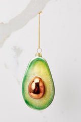 Front view of this ornament  that features a sparkly green avocado.