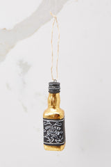 This gold and black ornament features a gold and black whiskey bottle.