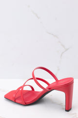 Inner-side view of  these heels that feature a square toe, red insole, three straps, black soles, and a wide heel.