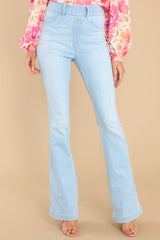 These light wash jeans feature flared legs, decorative front pockets, functional back pockets, and belt loops.