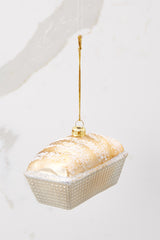 This brown and ivory ornament features a gold and glitter encrusted tin of bread. 